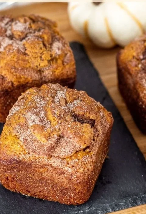 Slice of small batch cinnamon swirl pumpkin bread on a wooden board