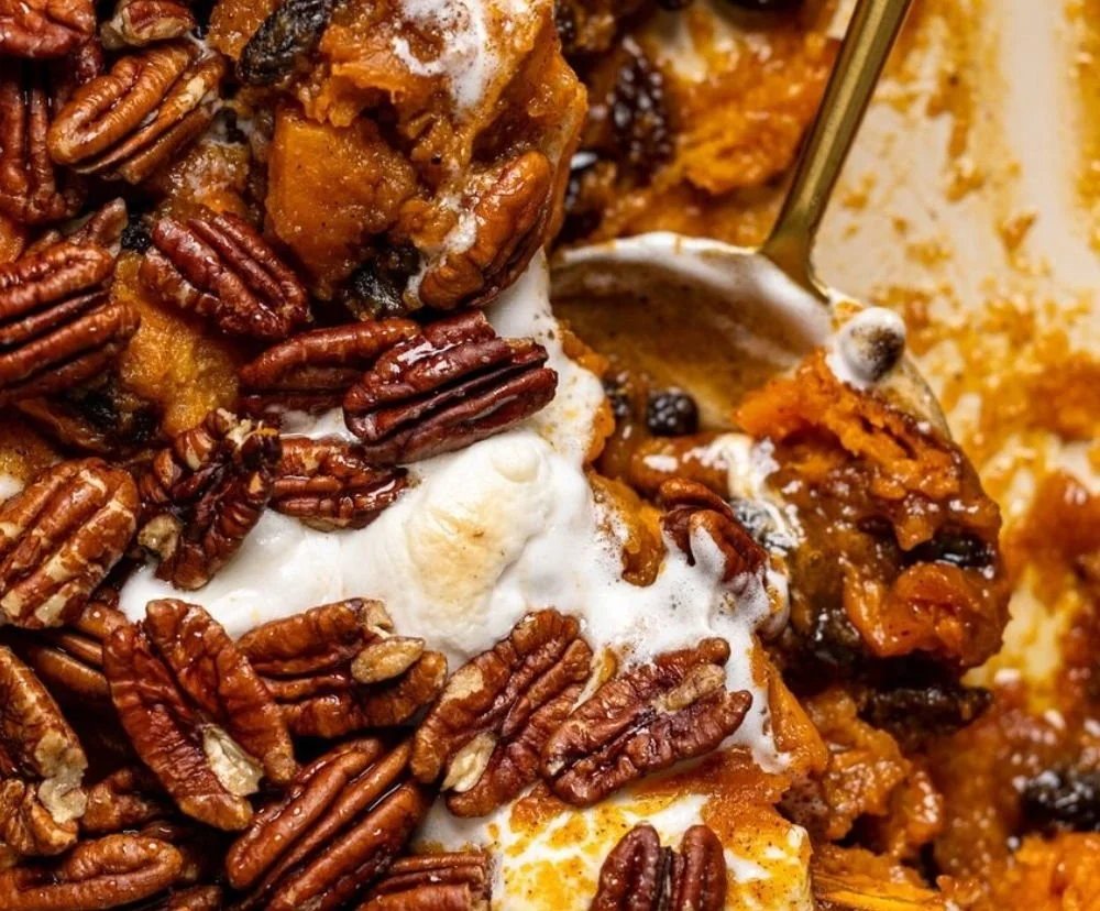 Southern Maple Sweet Potato Casserole topped with pecans and maple syrup.