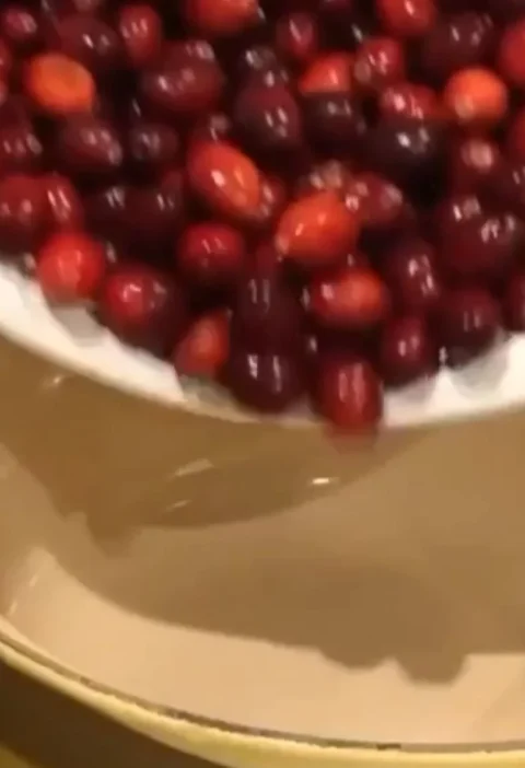 Homemade cranberry sauce served in a bowl with fresh cranberries and herbs