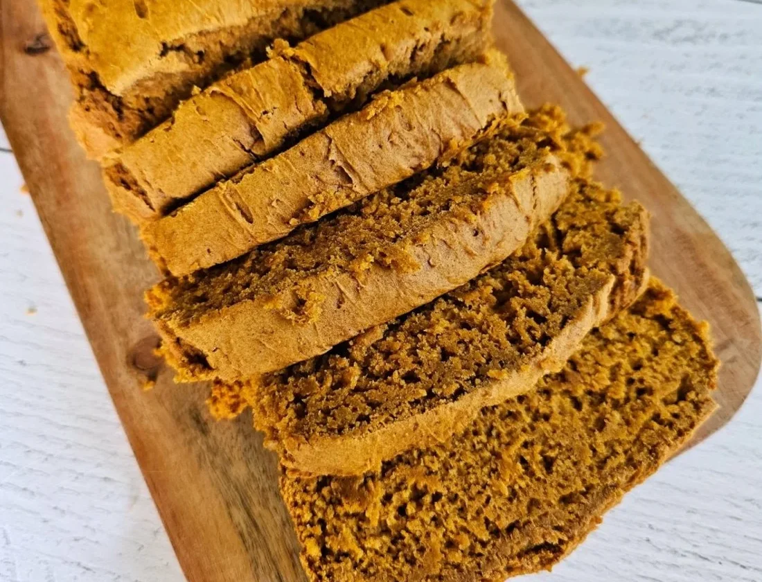 Delicious slice of two-ingredient pumpkin spice bread on a wooden table.