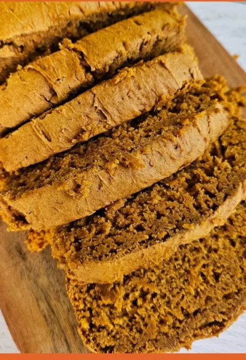 Delicious slice of two-ingredient pumpkin spice bread on a wooden table.