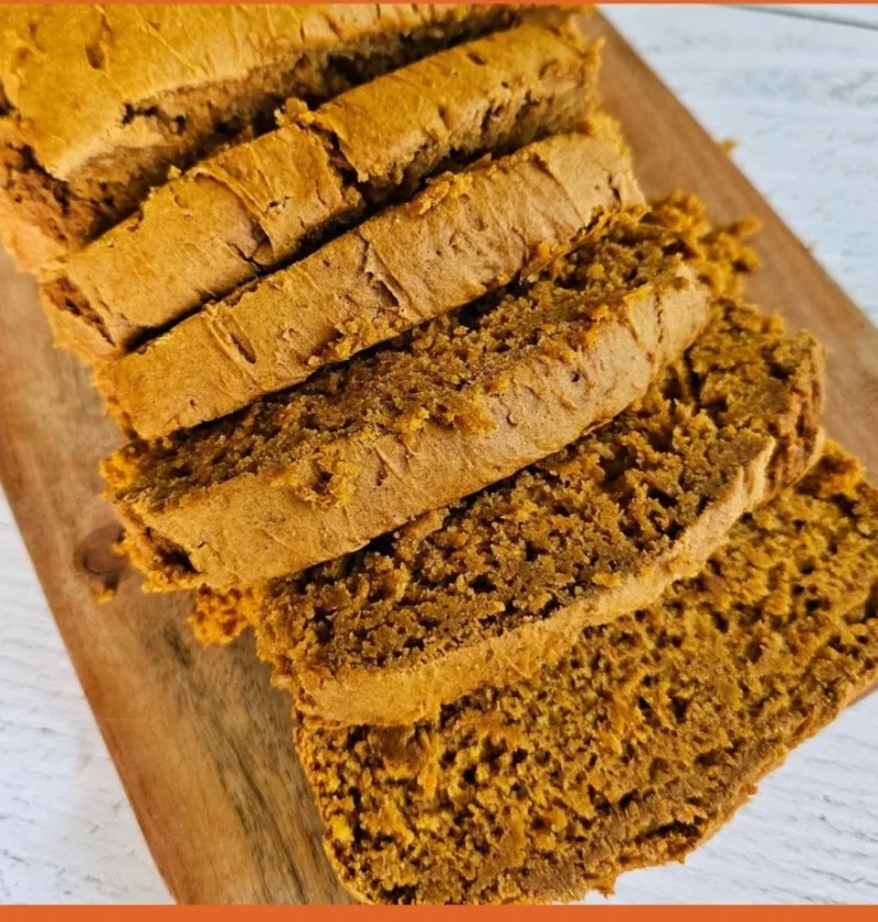 Delicious slice of two-ingredient pumpkin spice bread on a wooden table.
