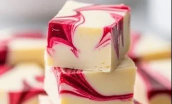 Delicious white chocolate raspberry fudge cut into squares on a plate